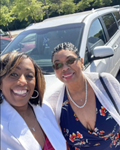 Image of mom and daughter smiling in front of car.